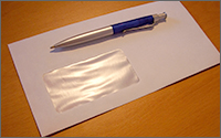 A pen resting on top of a blank envelope.