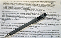 A pen sitting on top of a paper that has illegible text and many corrections.