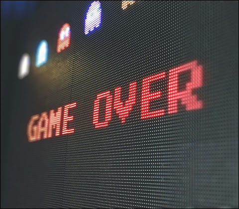 8-bit black screen featuring the Pac-Man game over screen with capitalized red text displaying 'GAME OVER'.